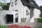 The picture shows an air source heat pump outside a house